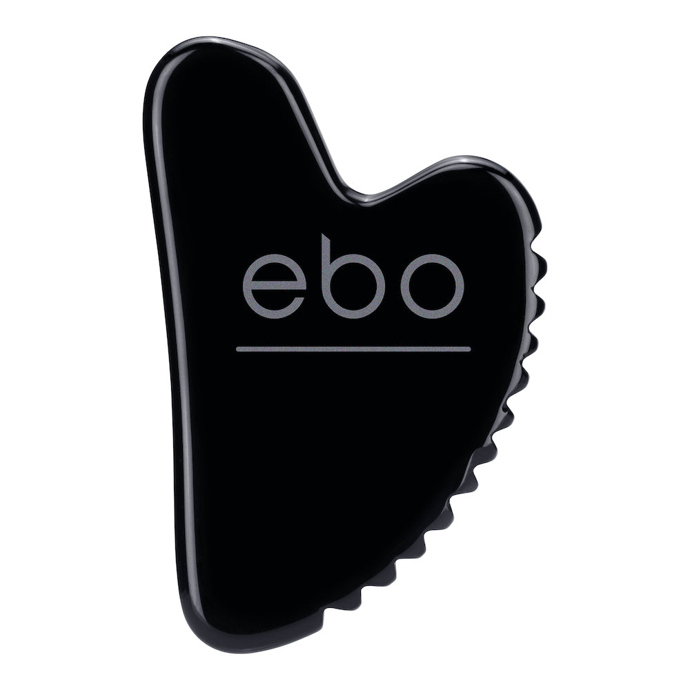Image of the obsidian face tool, The Wrinkle EaterTM on a white background. The Wrinkle Eater TM has smooth edges and perfect proportions to hug your face, as well as a unique jagged edge that grips and releases tight muscles.