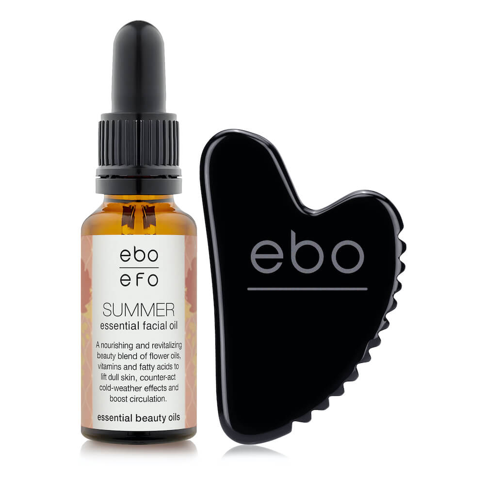 The Wrinkle Eater TM black obsidian face tool next to a bottle of ebo's summer essential facial oil.