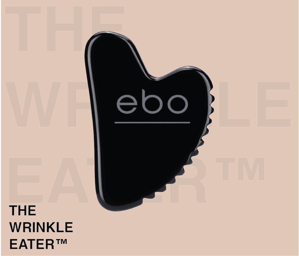 An image of black, obsidian The Wrinkle Eater TM on a cool pink background.